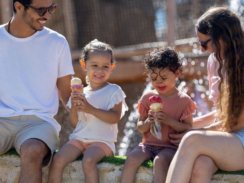 Couple de jeunes parents avec leurs enfants en train de manger des glaces dans le ZooParc de Beauval